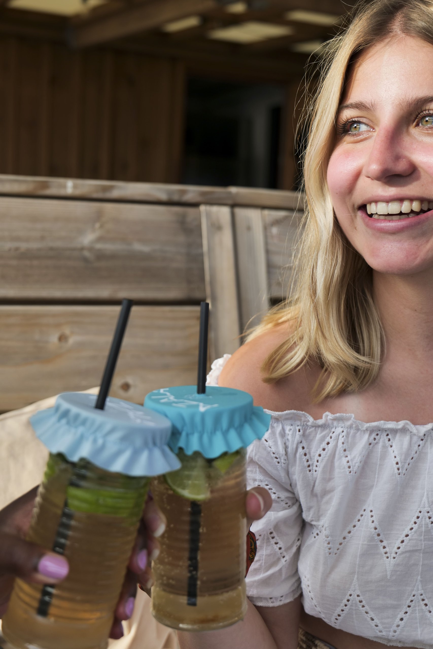 Azala — jeune femme riant avec deux verres couverts