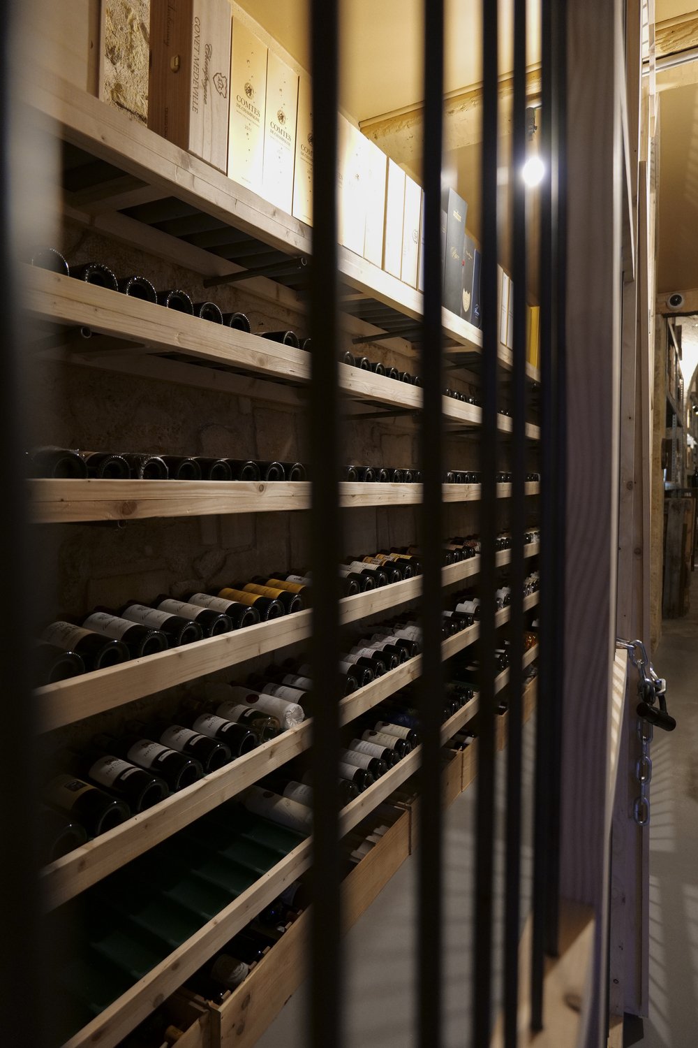 BTC Wine — rayonnages de bouteilles derrière une grille