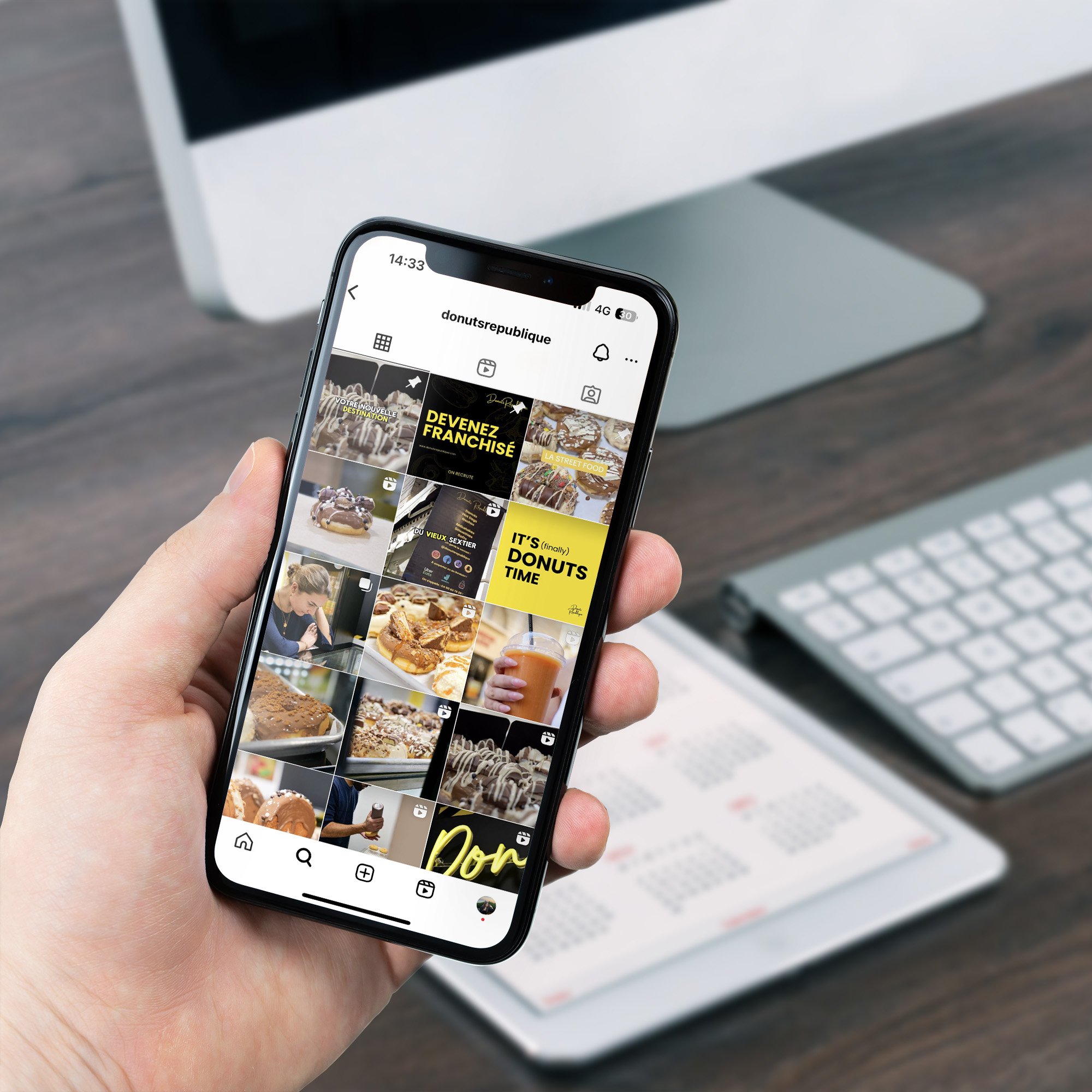 Donut's République — main tenant un téléphone ouvert sur le compte de la marque