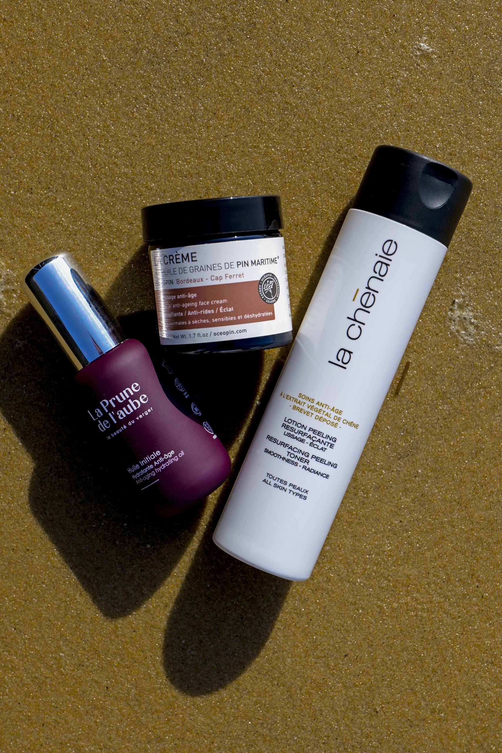 Peau Éthique — sélection de soins vus du dessus sur le sable
