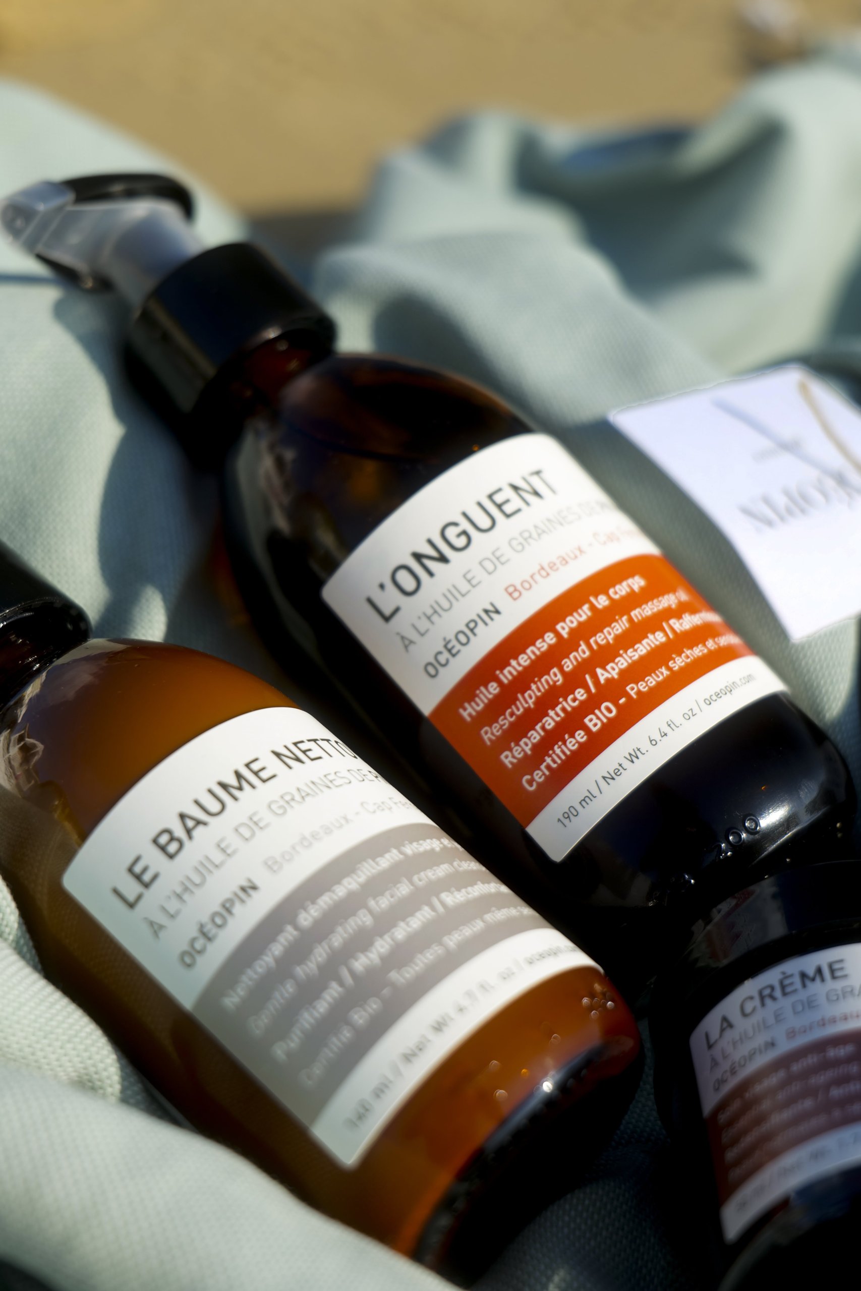 Peau Éthique — baumes en flacons ambrés sur un tissu