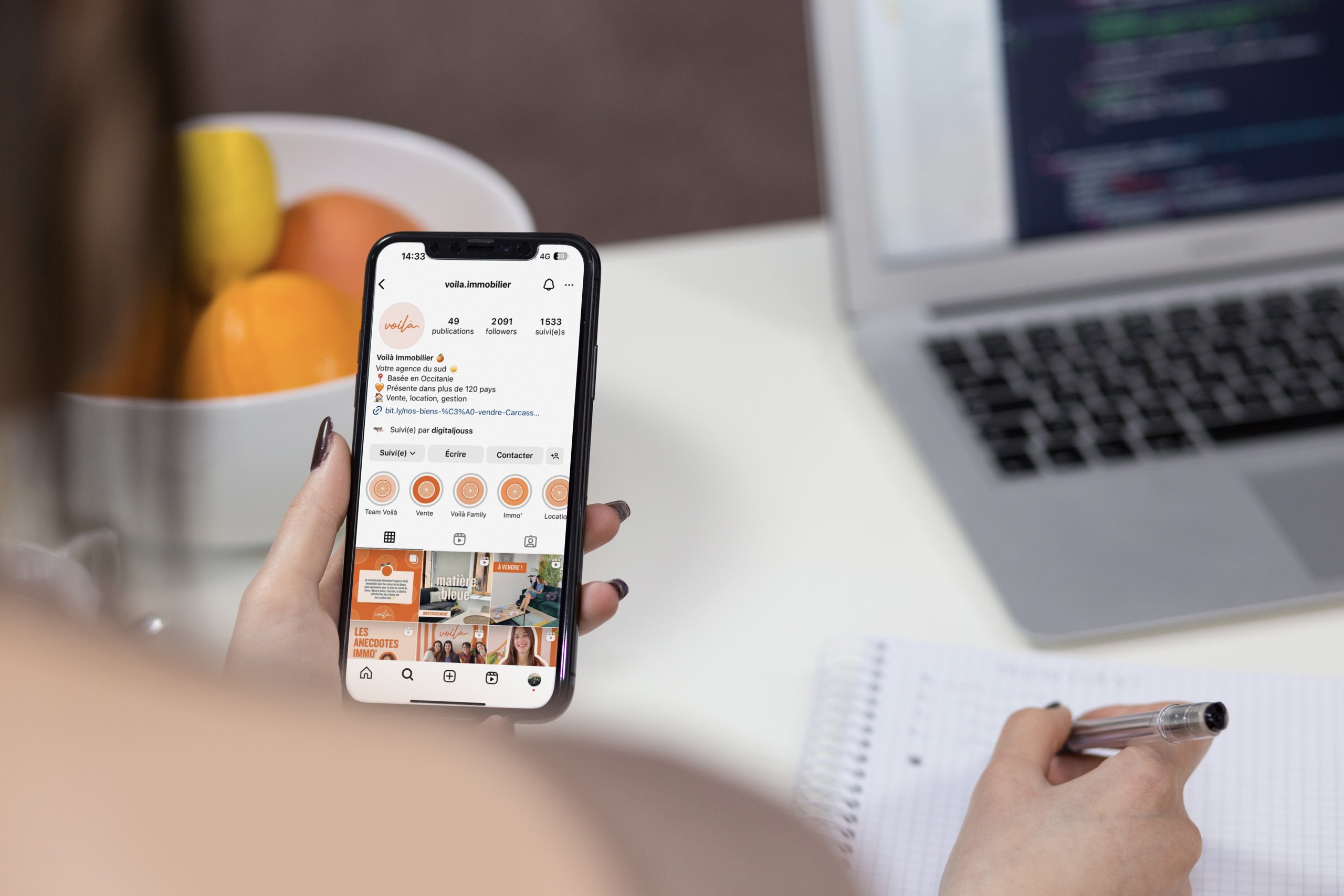 Voilà Immobilier — personne consultant le compte sur son téléphone à son bureau