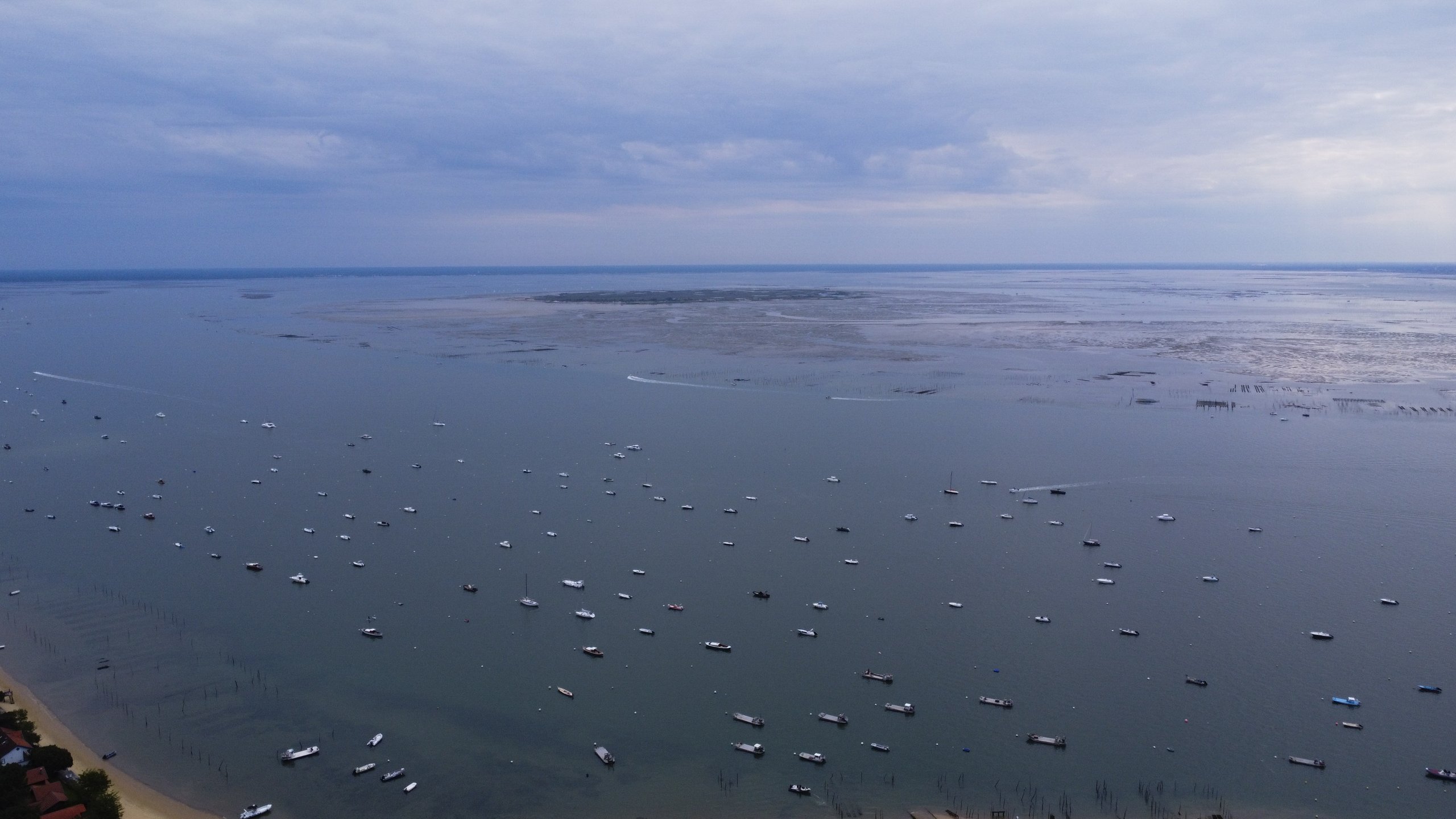 Vue d'en haut 4 Vue d'en haut — plan d'eau parsemé de bateaux sous un ciel voilé