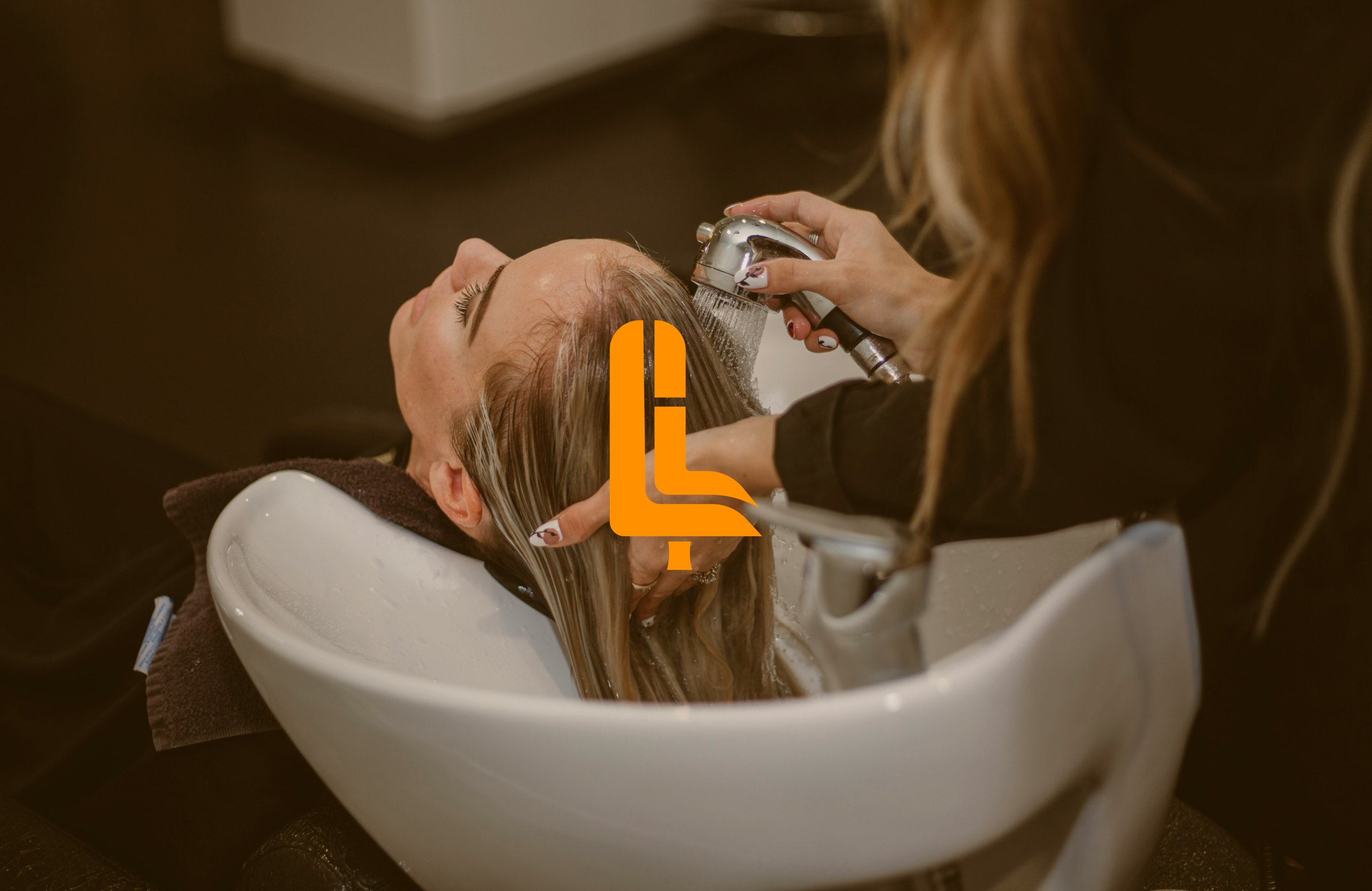 Fauteuil Libre : logo en orange sur une photo de salon de coiffure